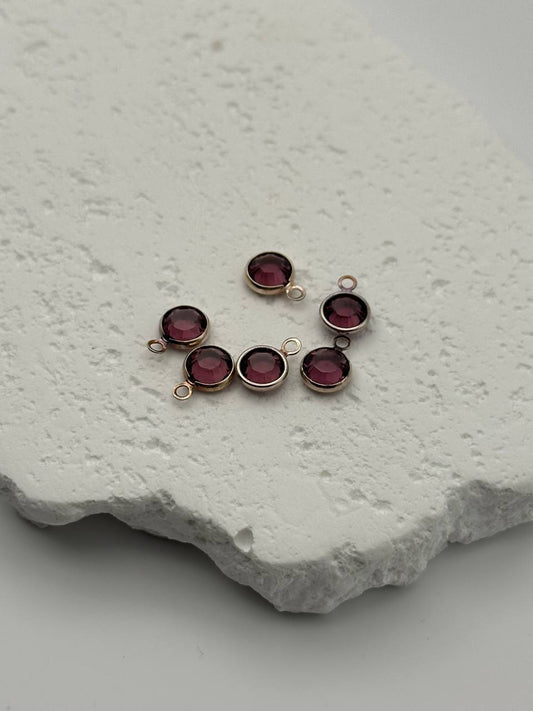 Amethyst chatons on a textured white surface