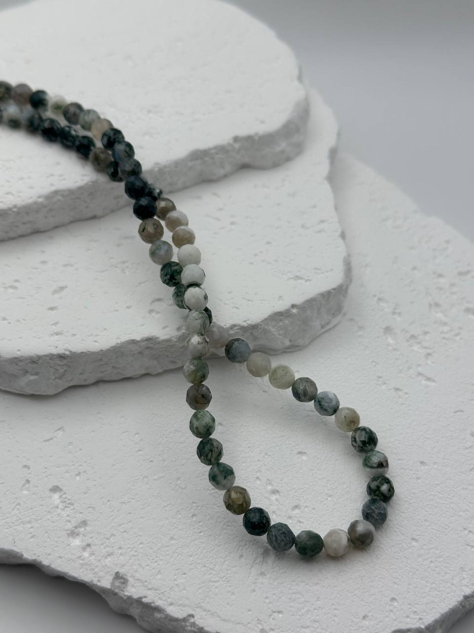 Beaded necklace on a textured white surface