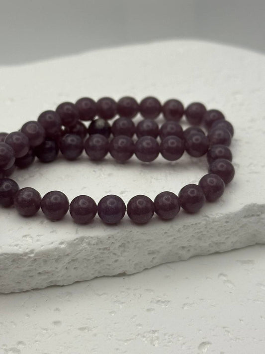 Lepidolite beads on white surface
