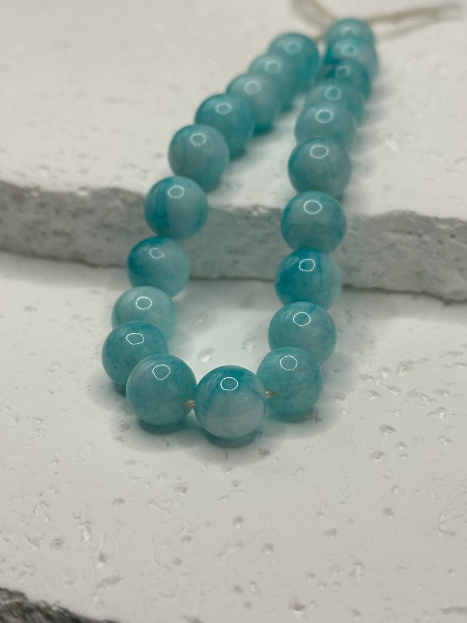 Turquoise beaded necklace on a textured surface