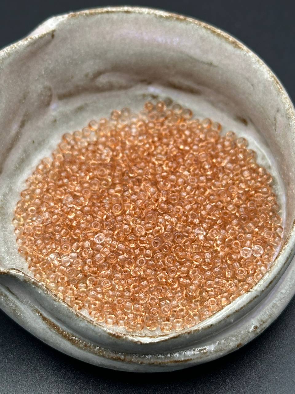 small container filled with light taupe beads