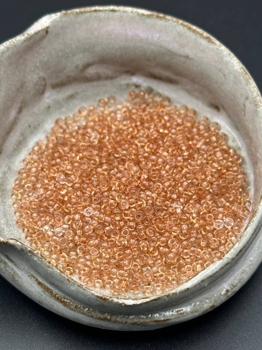 small container filled with light taupe beads