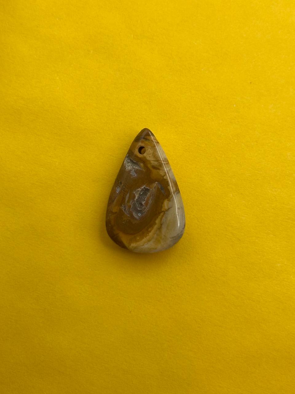 Teardrop-shaped stone on a yellow background