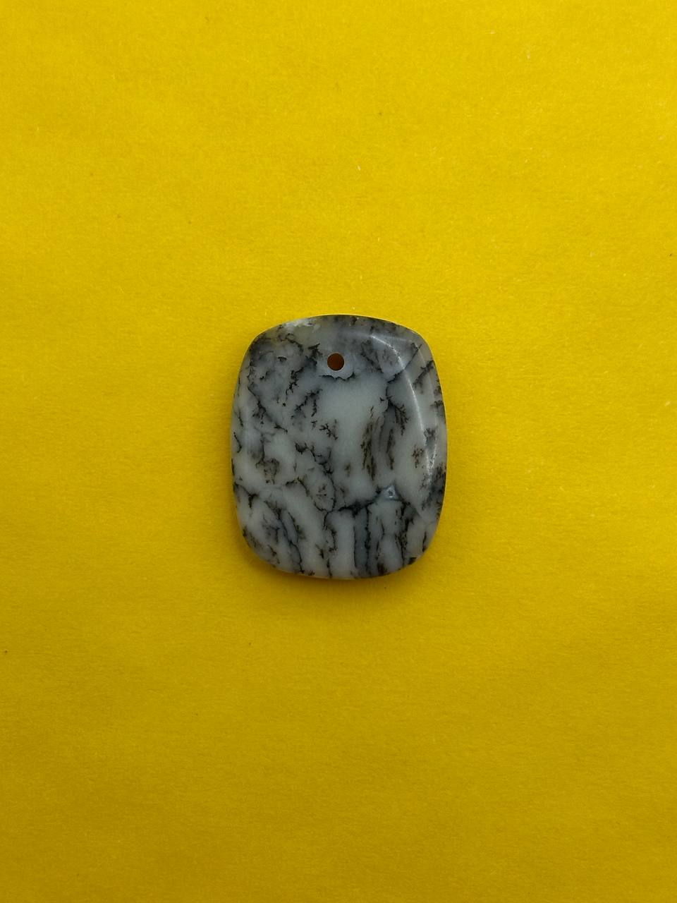 Decorative stone with black and white pattern on a yellow background