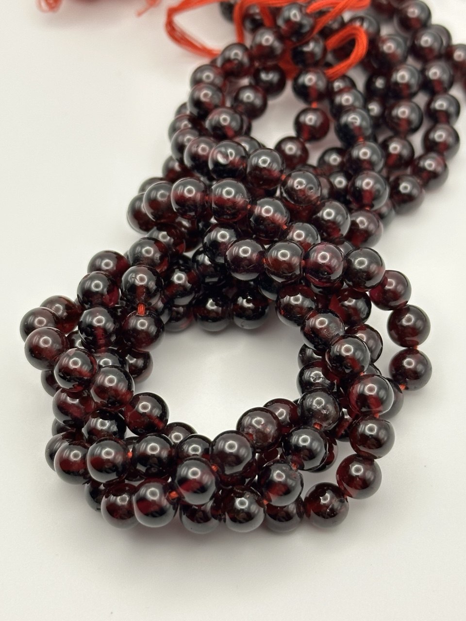 String of dark red beads on a white background