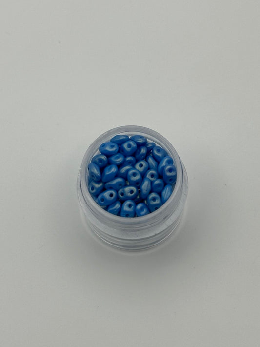 Small container filled with blue beads on a white background