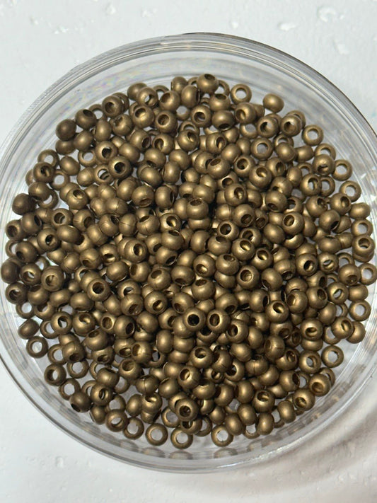 A small pile of genuine metal brass round size 6 seed beads
