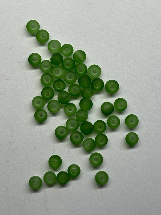 Green beads scattered on a white background