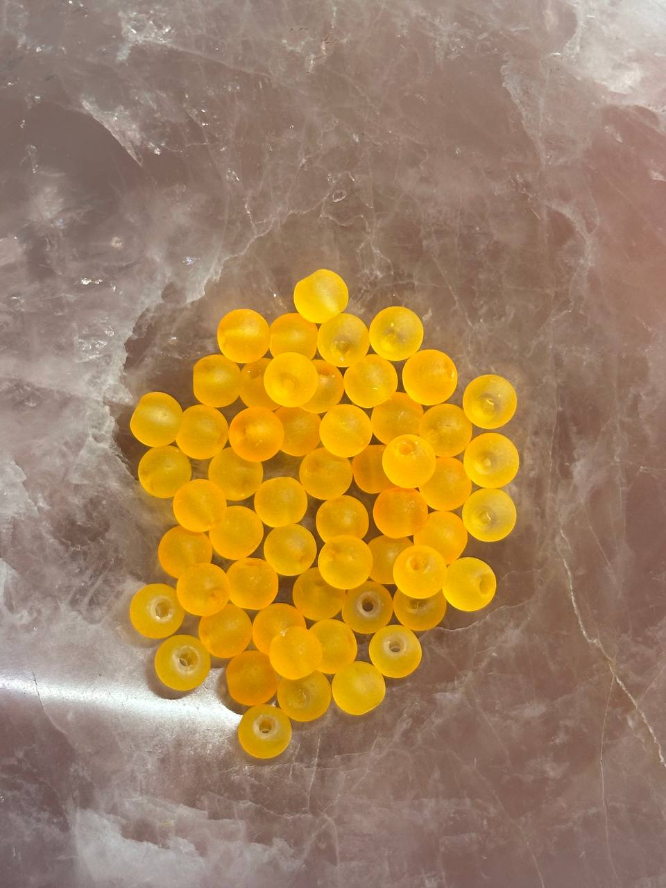 bright orange beads on a marbled surface