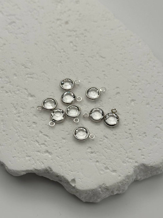 Silver jewelry components on a textured stone surface