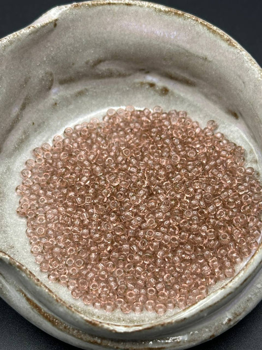 Close-up of small pink beads in a ceramic container