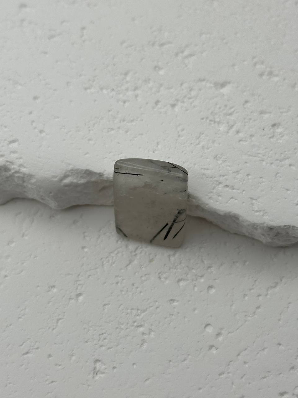 Close-up of a stone object on a textured white surface