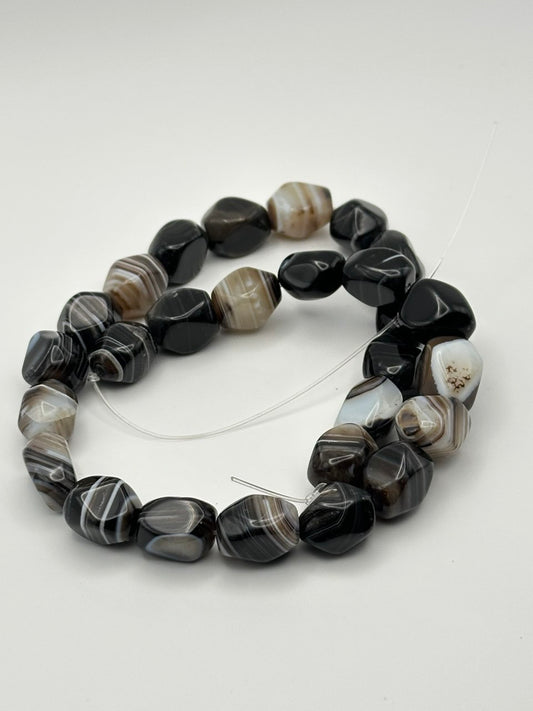 Botswana agate nugget tumbled beads on light grey background
