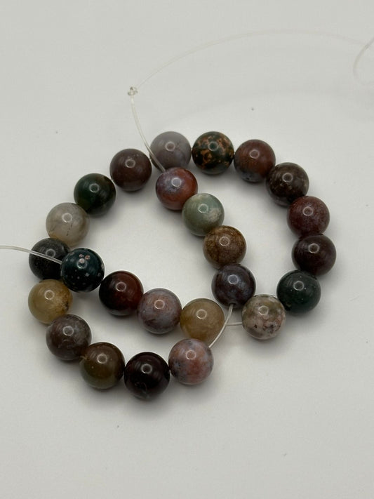 String of polychrome jasper beads on white surface
