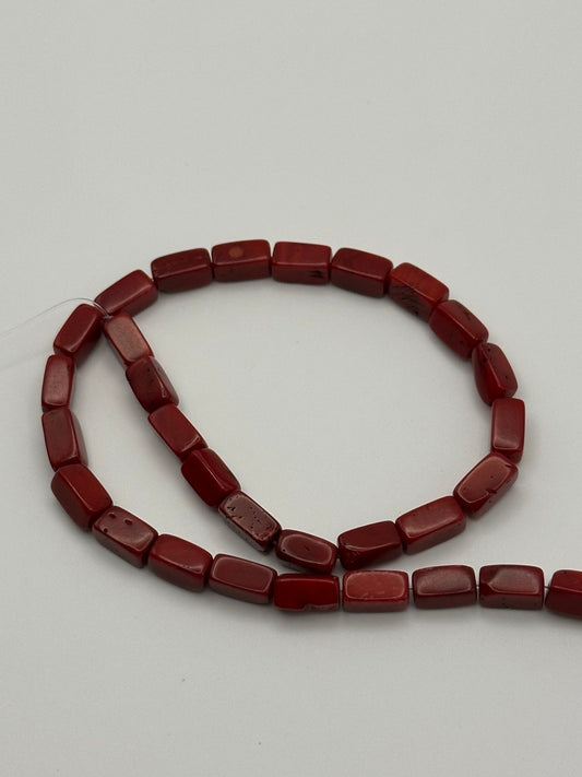 red coral rectangular beads on white surface