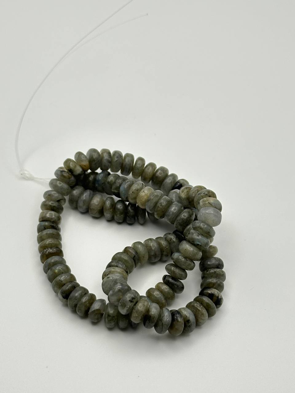 String of gray iridescent beads on a white background