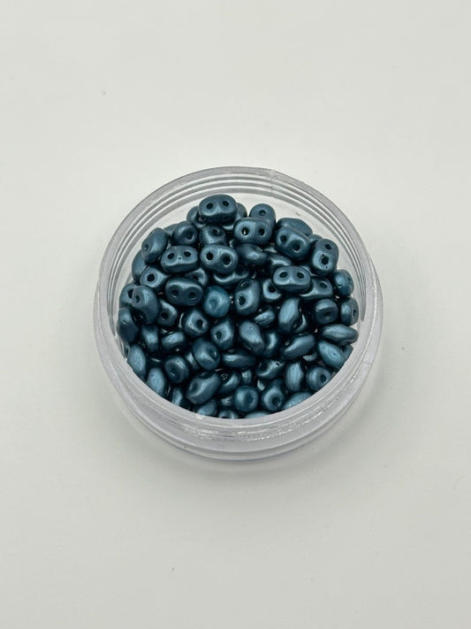 Clear container filled with blue beads on a white background