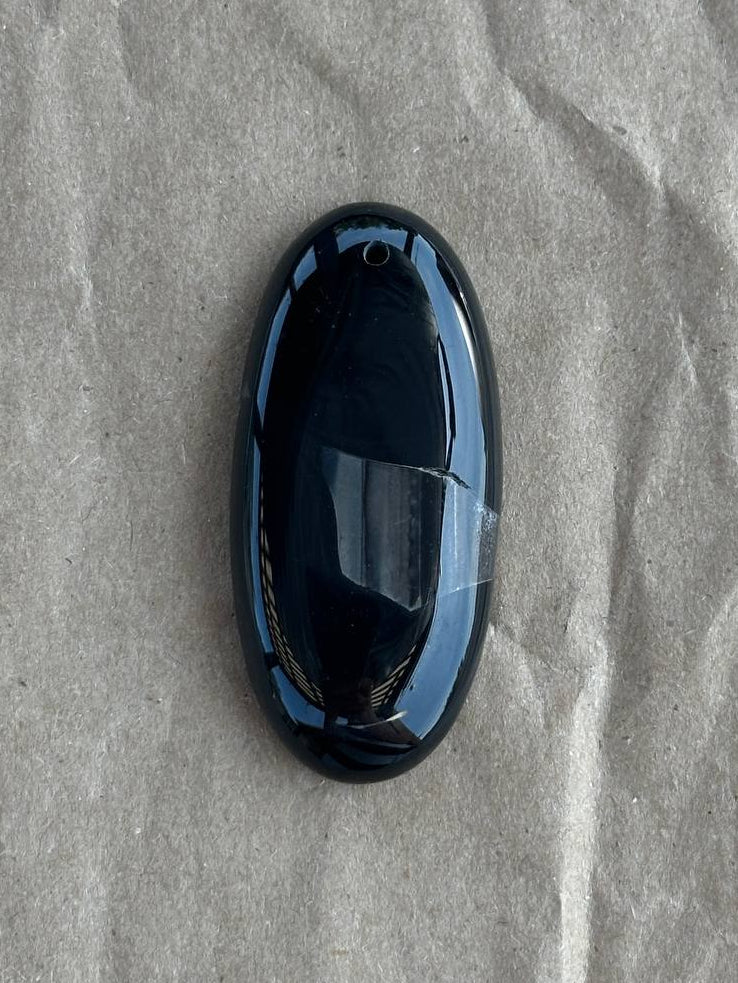 Black obsidian pendant on craft paper background