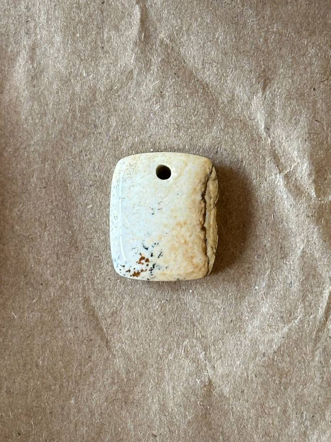 Picture jasper rounded rectangle cabochon on brown paper background