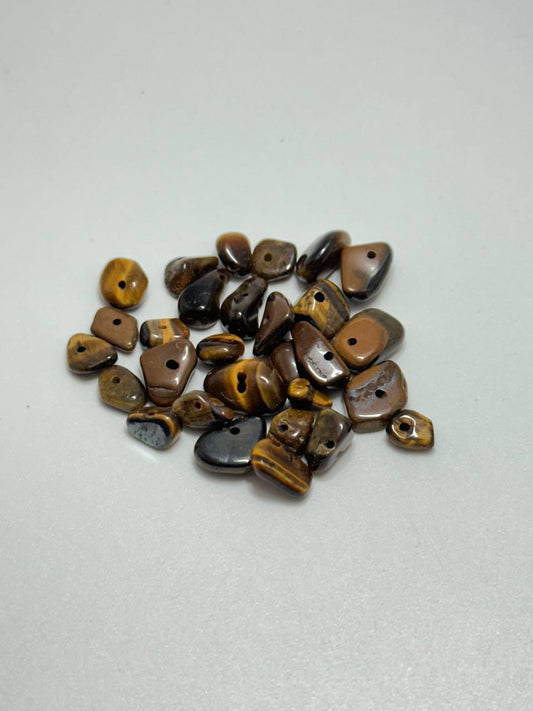 A small pile of tiger's eye chip beads on white background