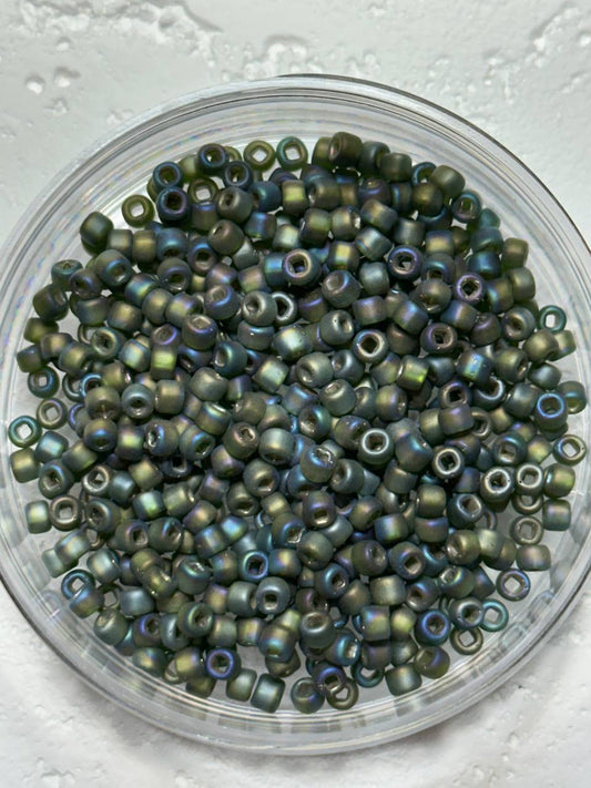 A small pile of size 6 matsuno rocaille iris seed beads on white surface