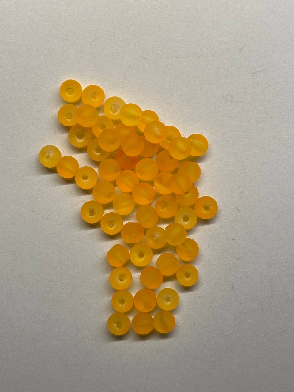 Orange beads scattered on a white background