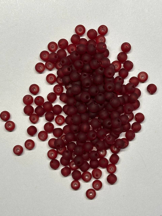 Burgundy beads scattered on a white background