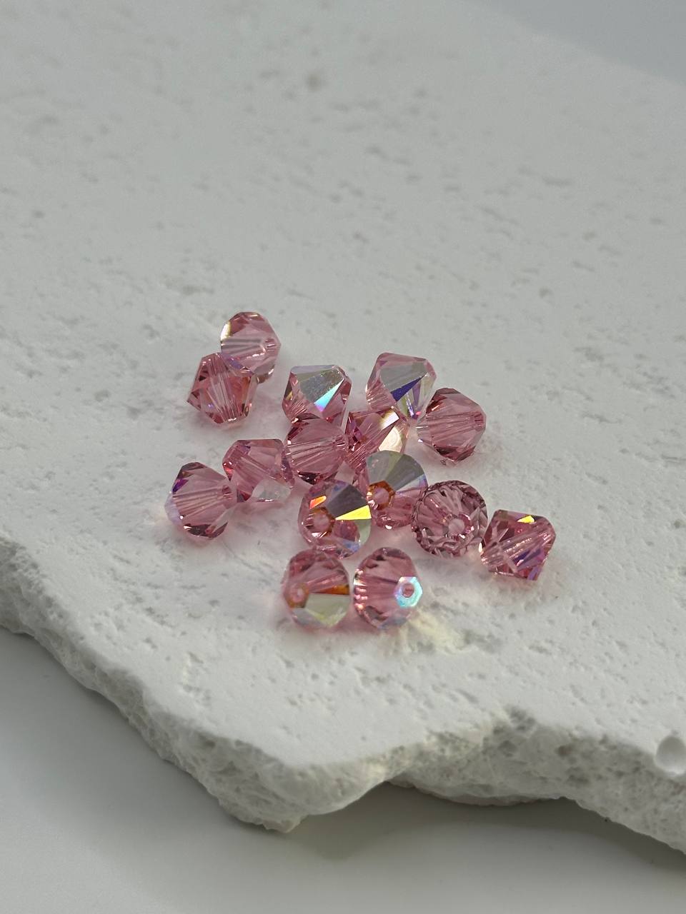 Pink crystal beads on a textured white surface