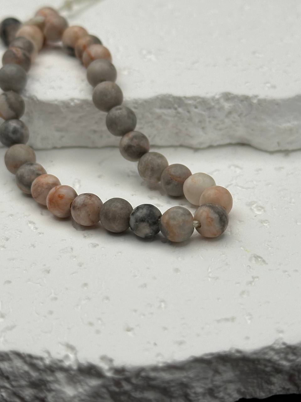 Beaded bracelet with natural stone beads on a textured surface