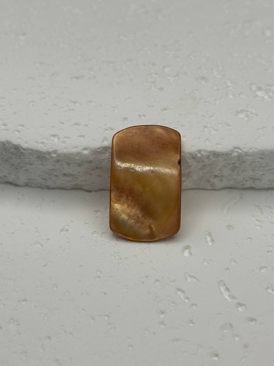 Brown pearl on a textured white surface