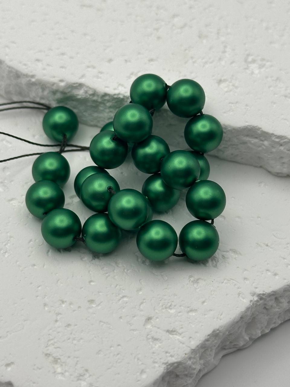 Green beads on a white stone surface