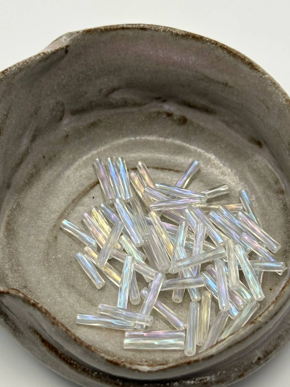 Iridescent crystal glass beads in a gray pot