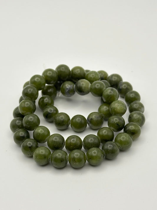 dark green semi-precious round beads on white surface