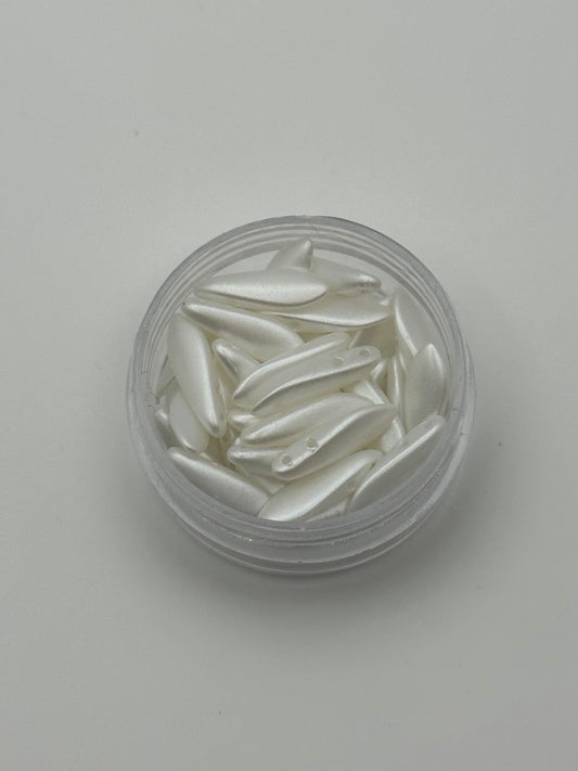 Clear container with white decorative dagger beads on a light gray background