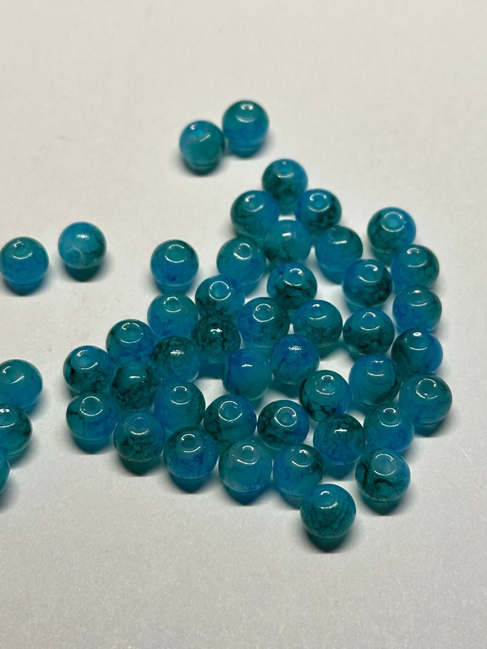 Blue beads scattered on a light gray background