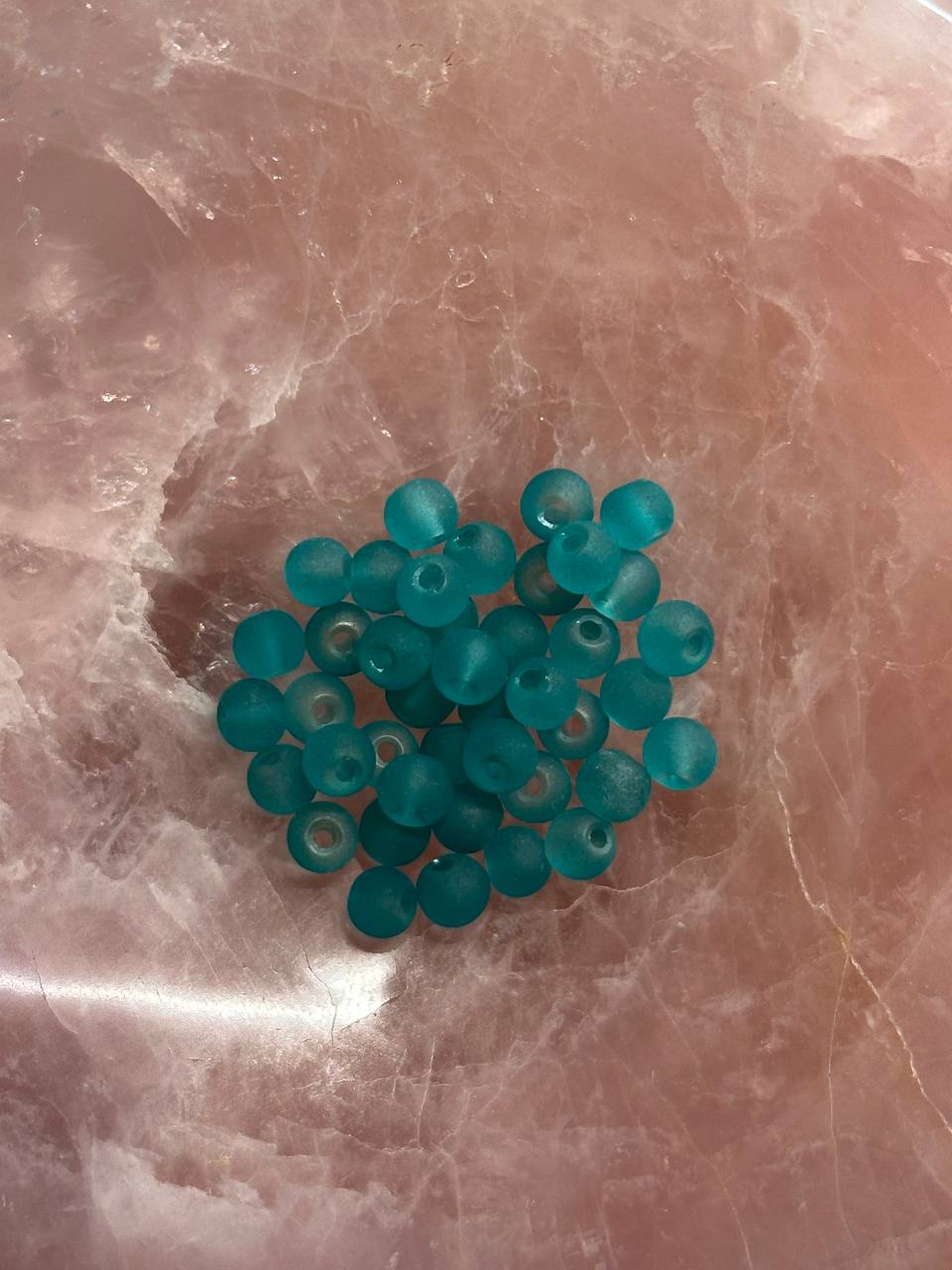 Turquoise beads on a marbled surface