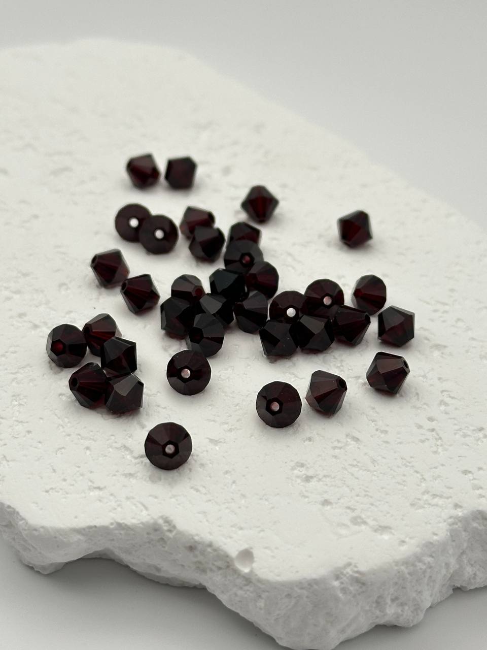 Dark red beads on a textured white surface