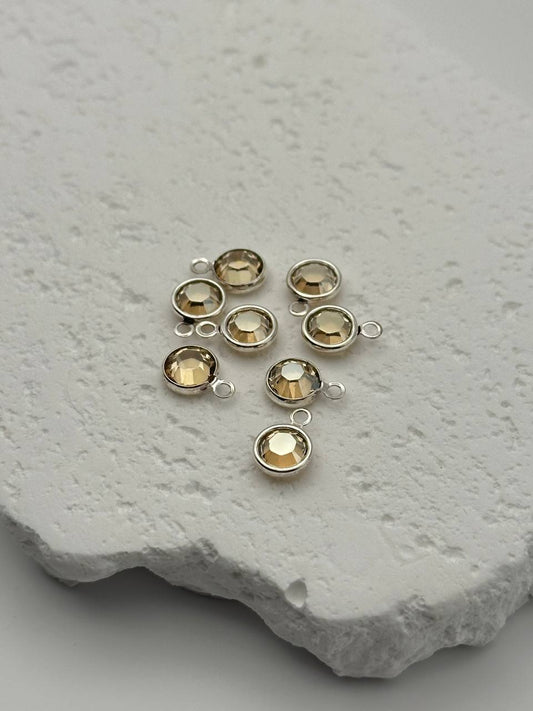 Jewelry components with chatons on a textured stone surface