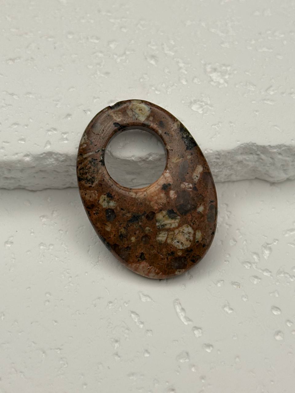 Jasper bead with a big hole on a light gray background