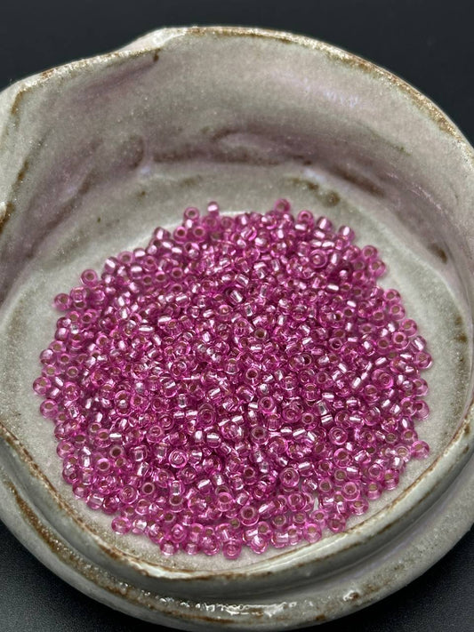small container filled with magenta beads