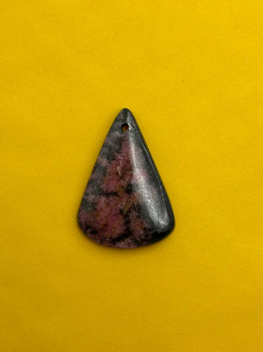 Triangular stone pendant on a yellow background