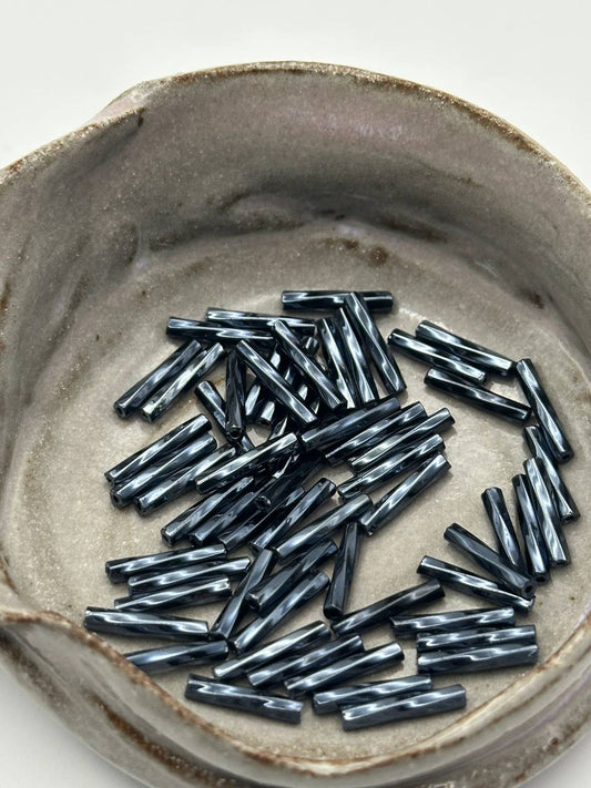 Dark cylindrical objects on a textured ceramic plate