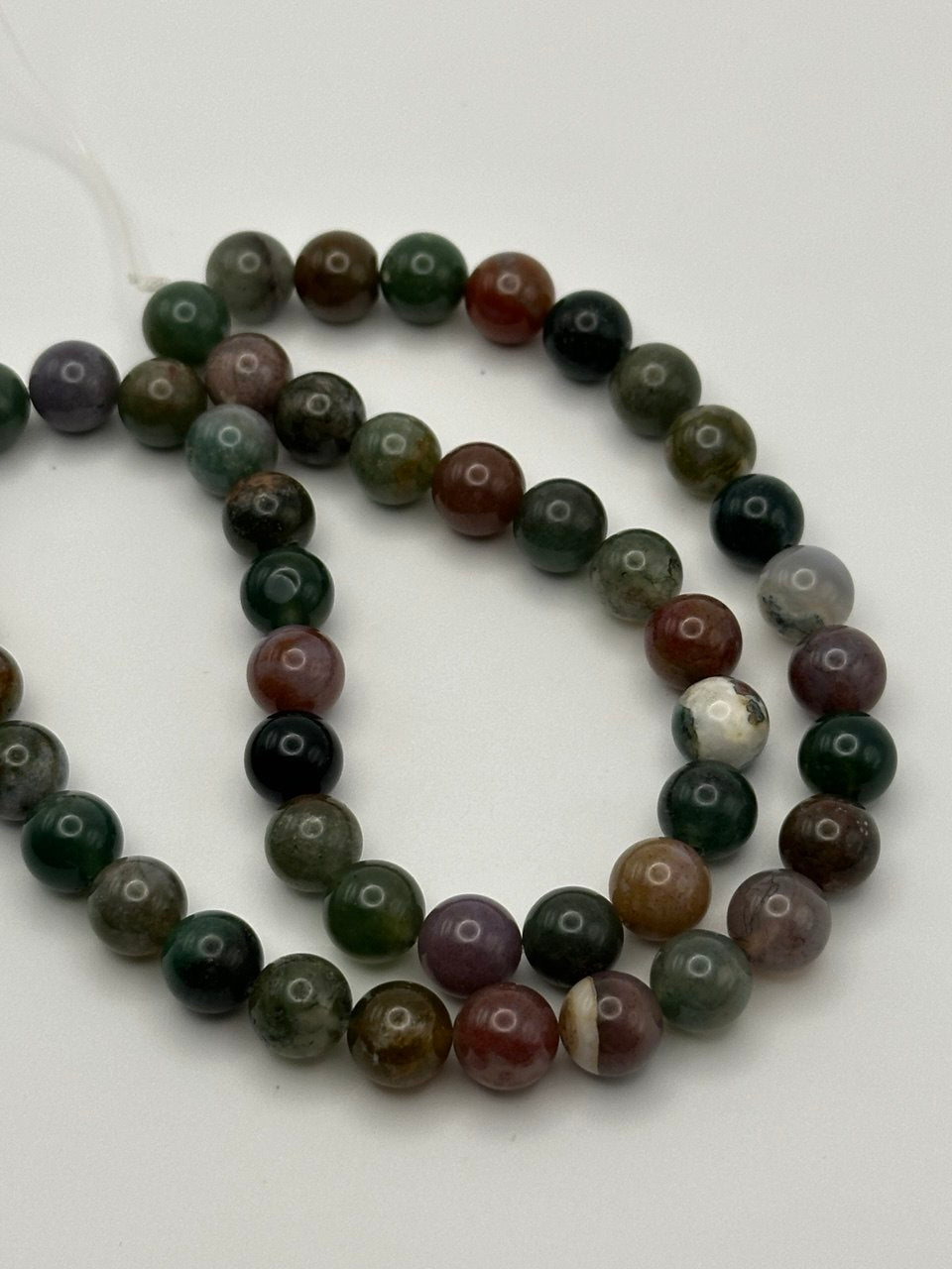 Multicolored jasper beads on white surface