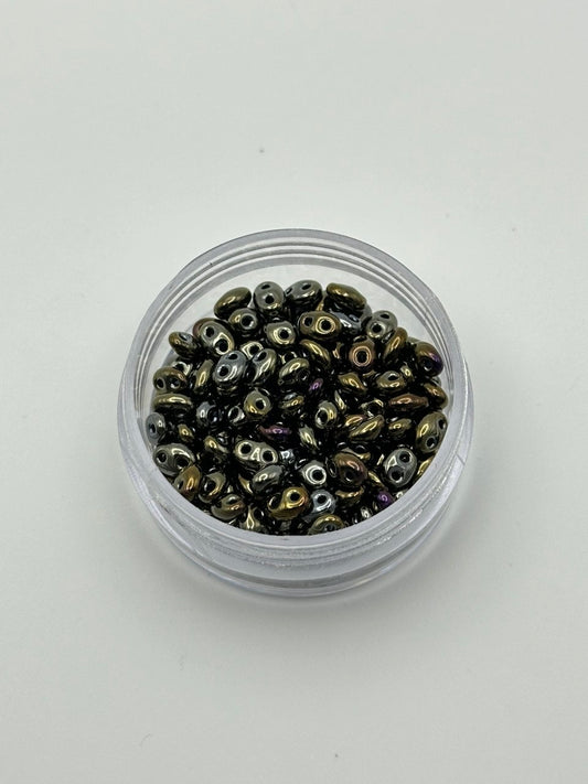 Small container filled with metallic beads on a white background