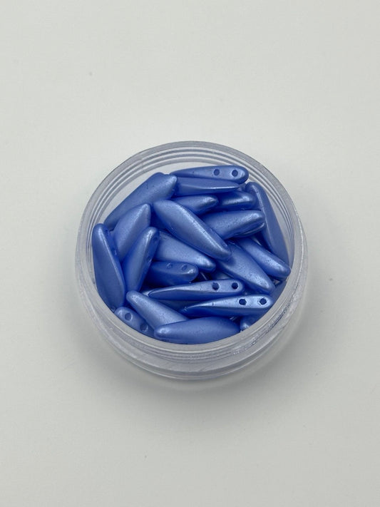 Clear container filled with blue dagger beads on a light gray background