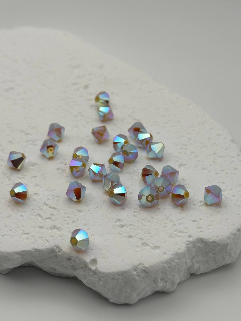 White opal shimmer bicone beads on white surface