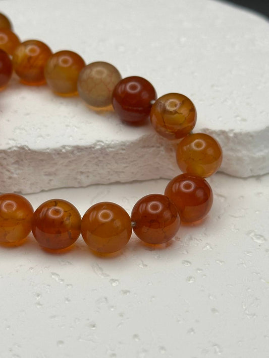 Close-up of a bracelet with orange beads on a white background