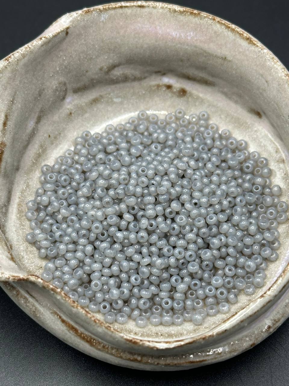 small container filled with grey beads