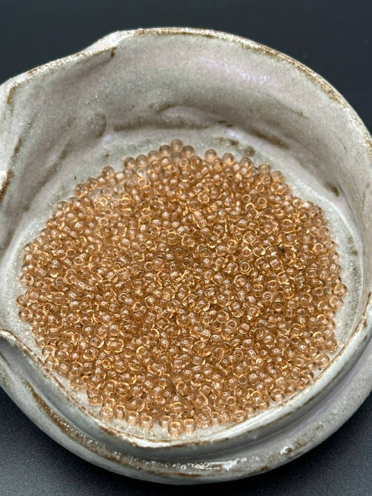 small container filled with light bronze beads