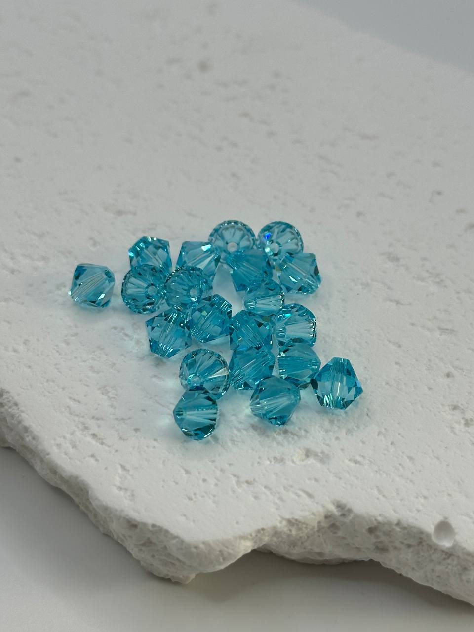 Turquoise beads on a textured white surface